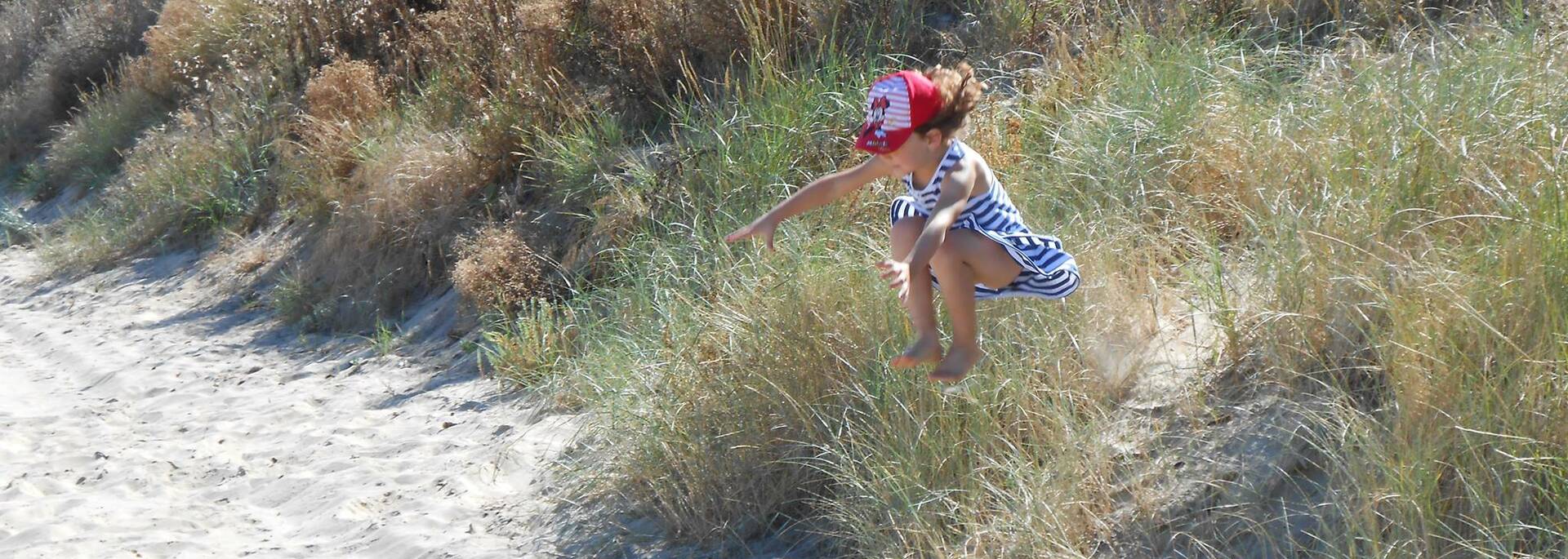 Enfant sautant dans les dunes de sable à Boyardville